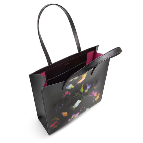 Black tote bag with colorful floral pattern and Ted Baker logo on a white background